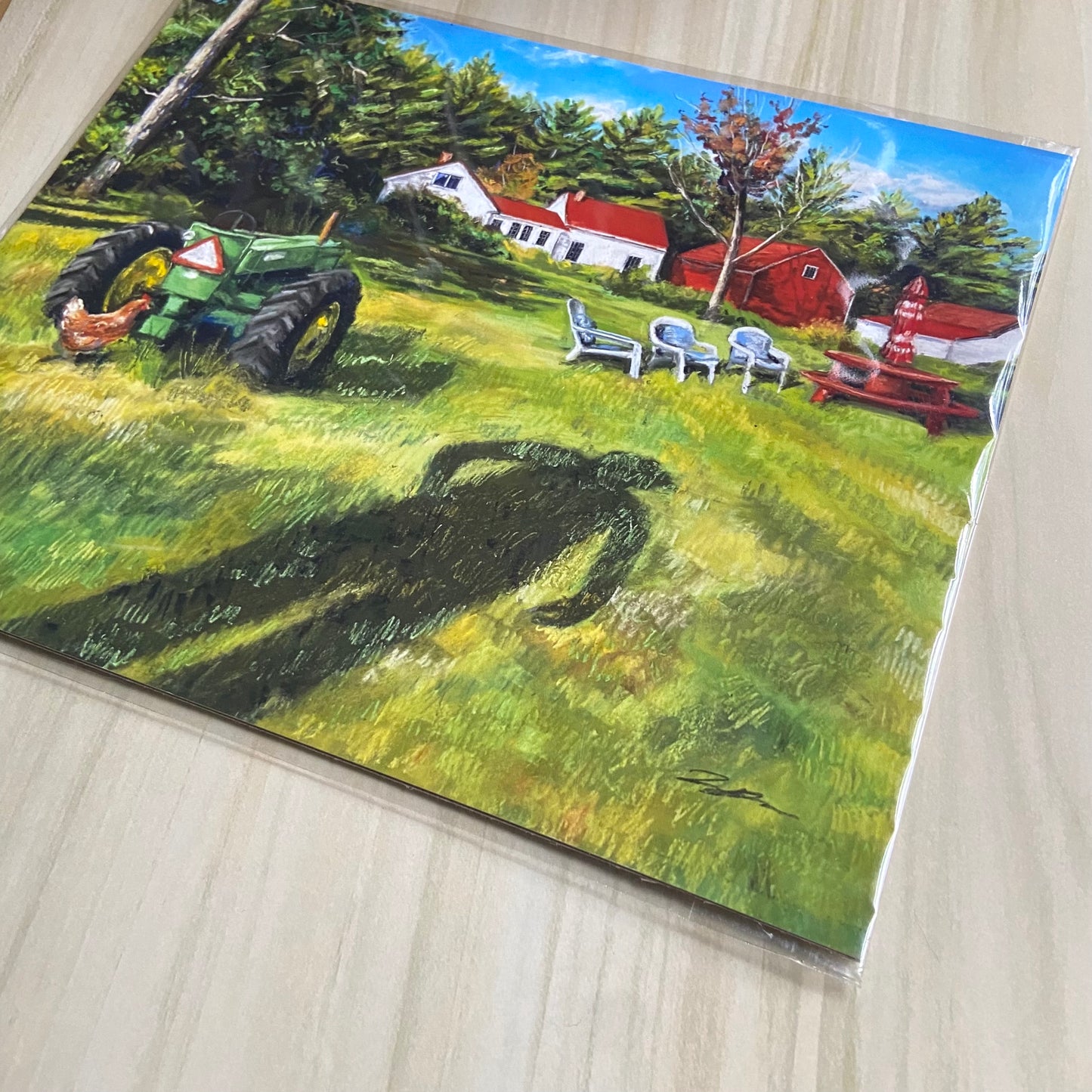 A detail look at the art print. The layered pastel texture of the grass can be seen, as well as the artist's signature. The green, blue and red colors are vibrant, showing a sunny day. The homestead farm scene is recognizably from rural New England.