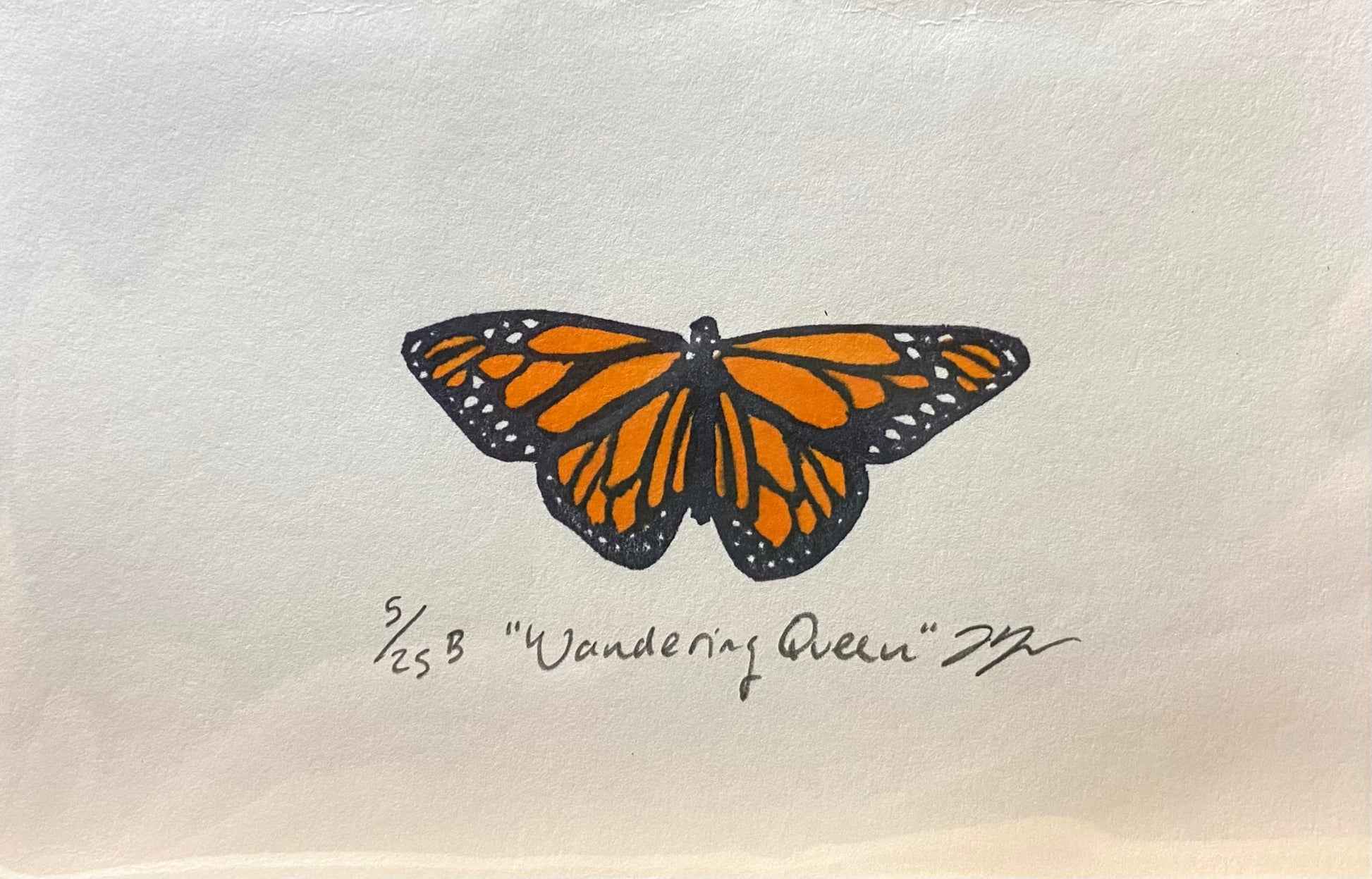 A relief print of a monarch butterfly, made by hand using a carved eraser. The print is numbered, signed, and titled "Wandering Queen".