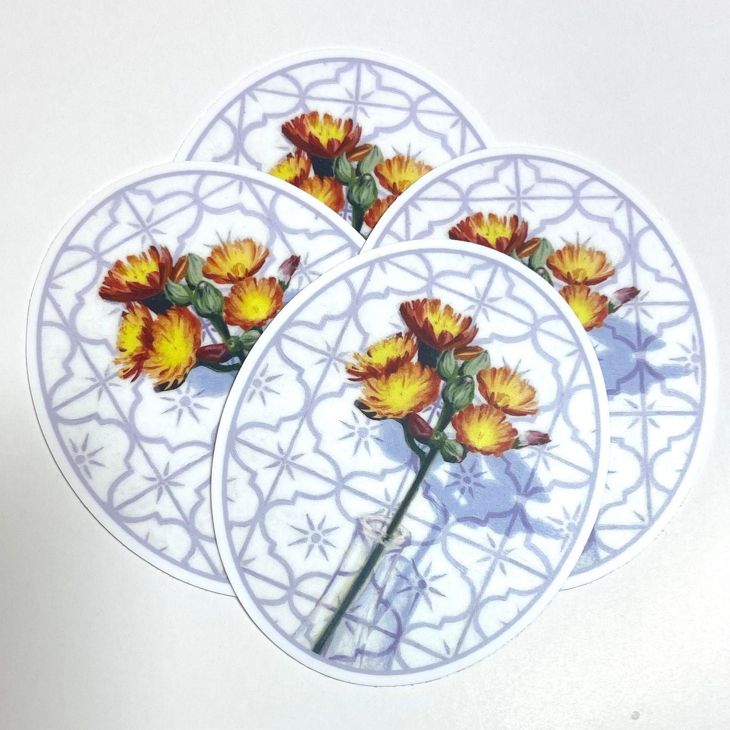 A pile of oval-shaped stickers depicting a painted hawkweed flower in a glass before a tile background.