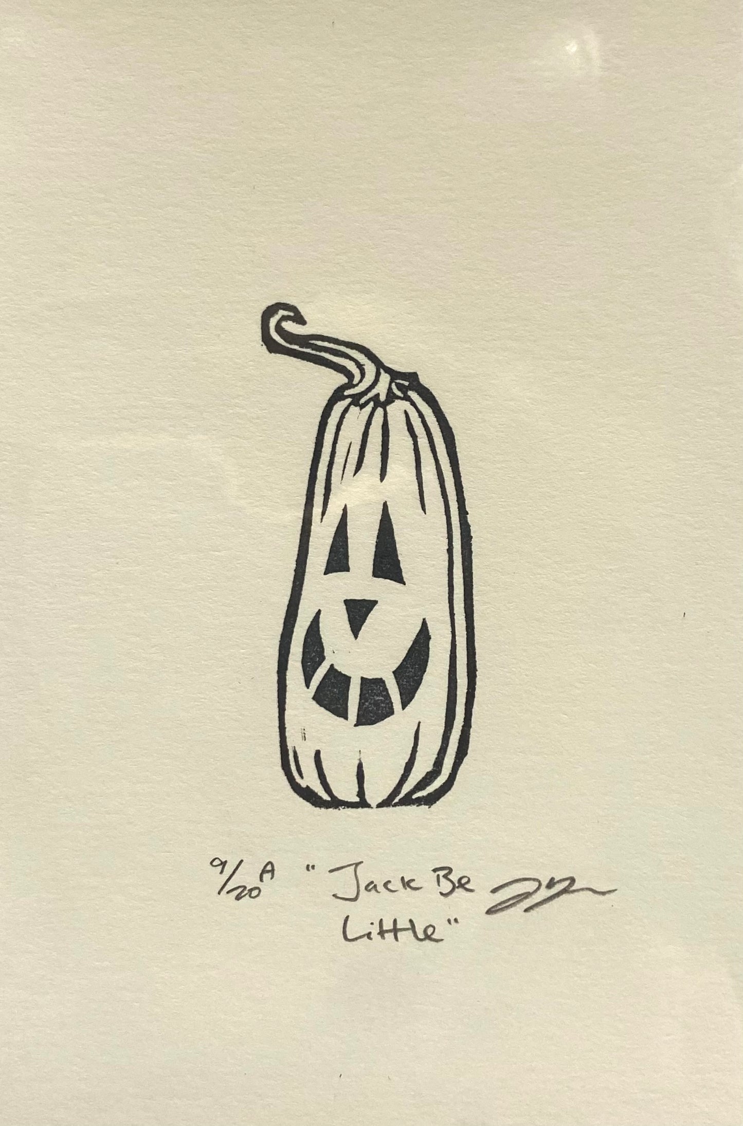 A small black-and-white print depicting a tall pumpkin with a carved jack-o-lantern face. The print is made by hand using a carved eraser and is numbered, titled and signed.