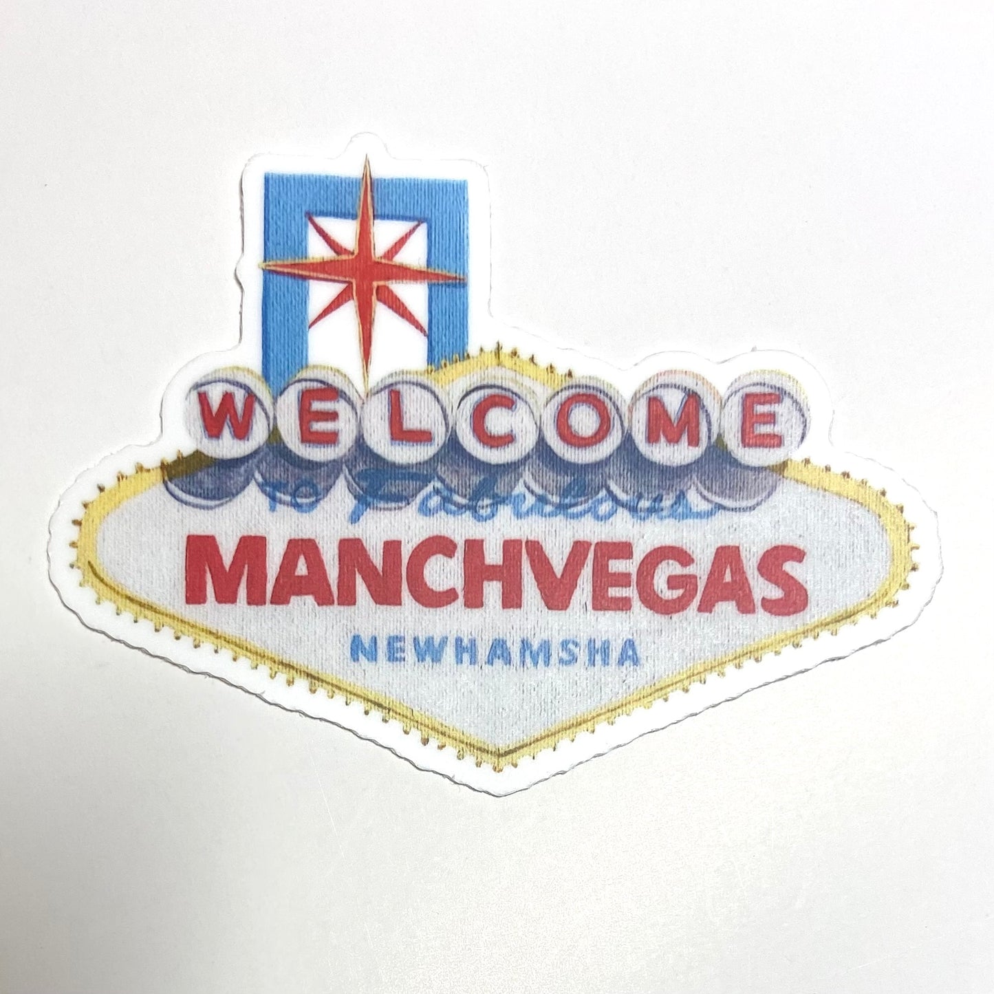 A sticker of the Las Vegas sign repainted to read "Welcome to Fabulous ManchVegas New Hamsha".