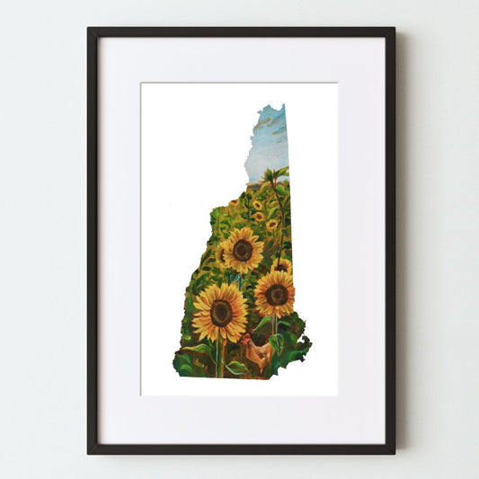 A mockup of the New Hampshire shaped landscape art print in a black frame with a white mat. The painting shows a sunflower field on a sunny day within the outline of the state of New Hampshire. Outside the painting area is white.
