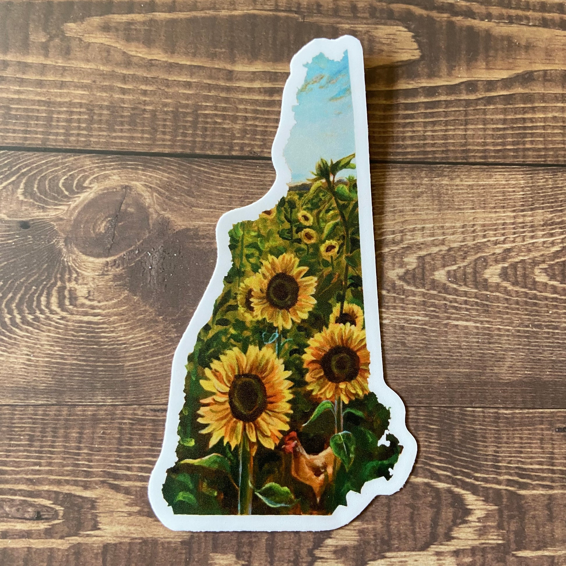 A durable vinyl sticker of my painting of a sunflower field in the shape of the state of New Hampshire.