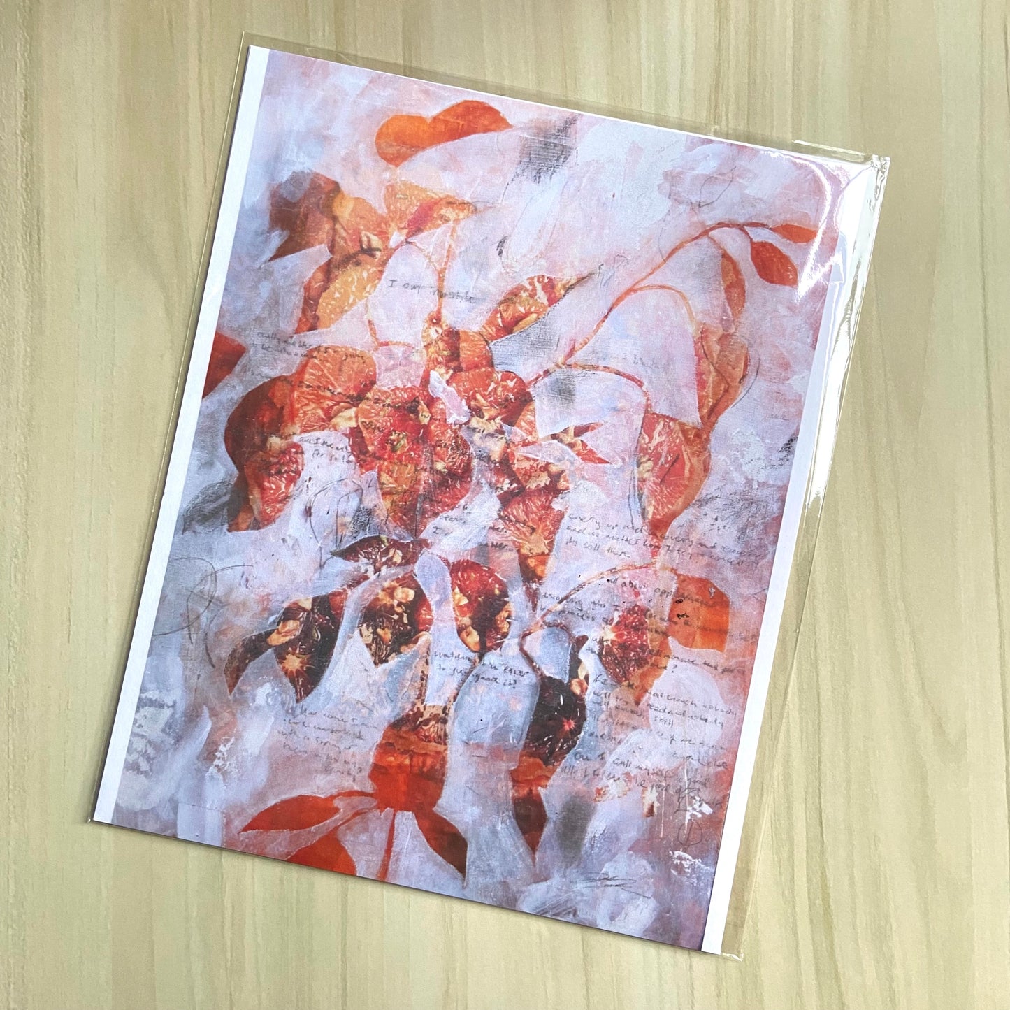 An art print of a collage and mixed media painting in orange and white. The image is a leafy plant, shown in orange, with thin, textural white paint layers outside the shape to create the silhouette. Small handwritten text/ pencil marks are on top.