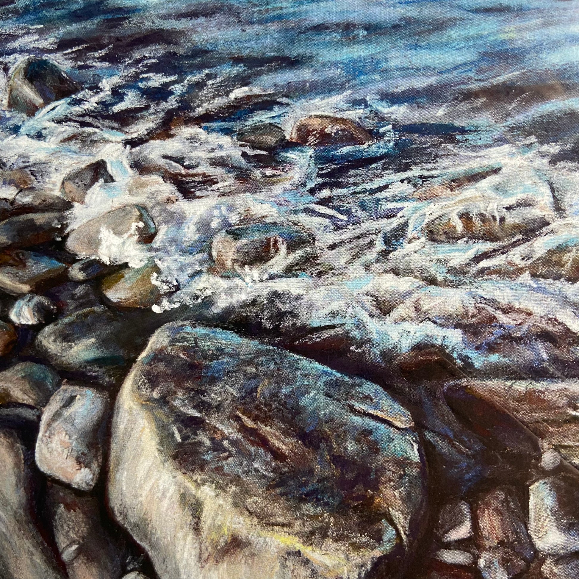 A close-up of the painting print shows the grainy effect of soft pastels, used to make the painting, and how they make both the oceanside rocks and white foam on the waves look real. This is a very cool-toned piece of artwork, good for a beach house.