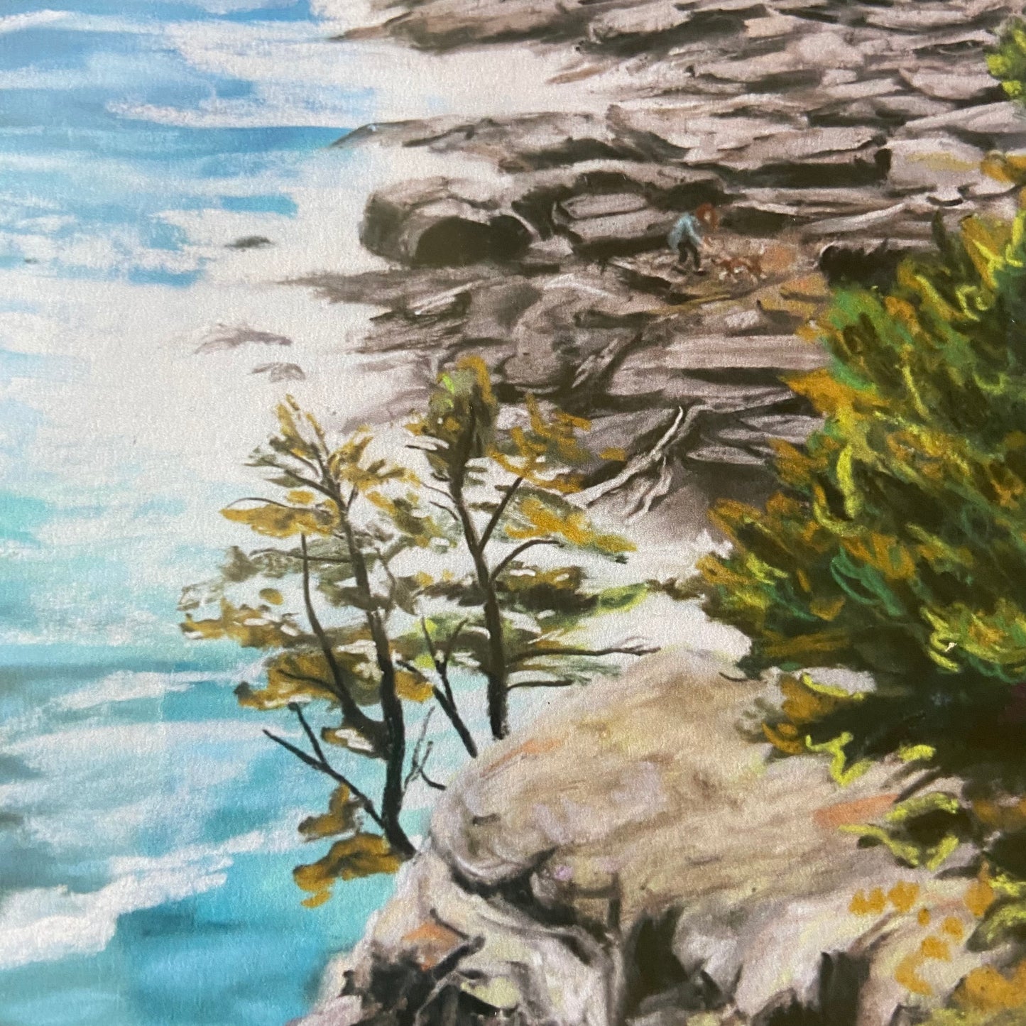 A close-up look at the scrubby coastal pine trees in the art print. You can see a woman and her dog on the rocky beach, a tiny Easter egg in the painting. This beach is clearly in New England, or especially Maine, and goes well with beachy decor.