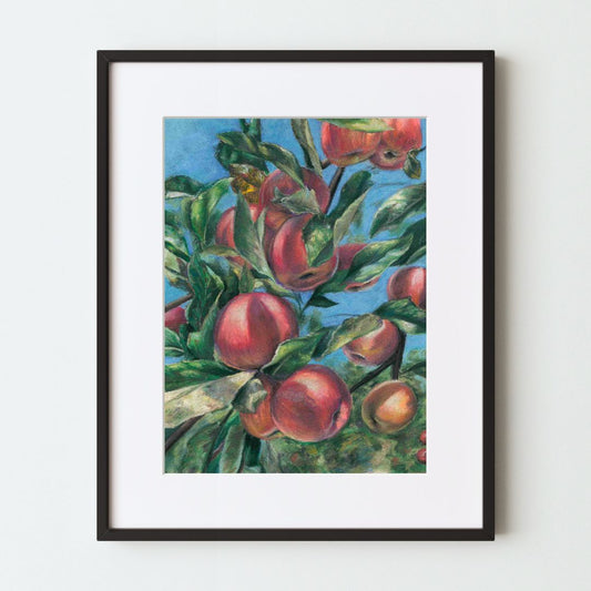 A mockup of a colorful art print in a black frame with a white mat. The painting, made with soft pastels, shows several ripe apples on a tree branch in the sun, in front of a bright blue sky. The light on the fruit and leaves is very realistic.