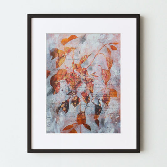 A mockup of an orange and white art print in a black frame with a white mat. An orange photograph is the base, with semi-opaque white paint applied in negative space to leave the silhouette of a plant. On top is various graphite markings and writing.