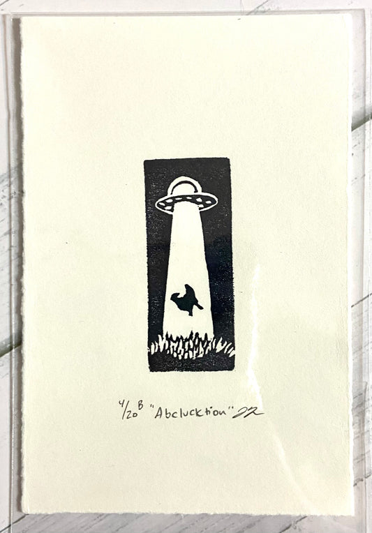 A black and white relief print of a chicken being taken by a UFO. the print is made by hand from a carved eraser and is numbered, signed and titled. 