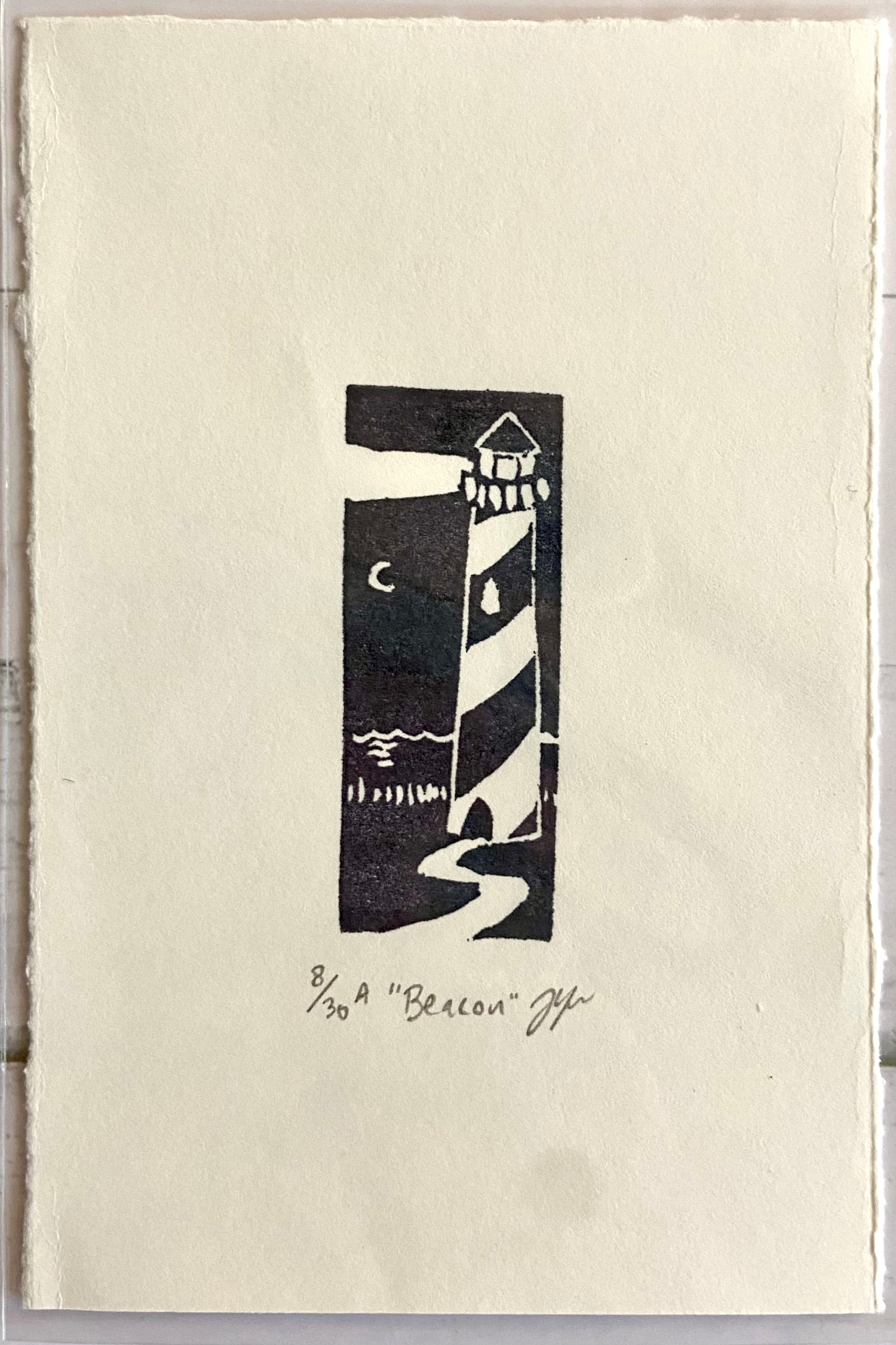 A handmade print of a lighthouse by a beach at night, stamped in black on white paper. Eraser prints are made by carving pink erasers and stamping them. The print is titled "Beacon", signed and editioned.