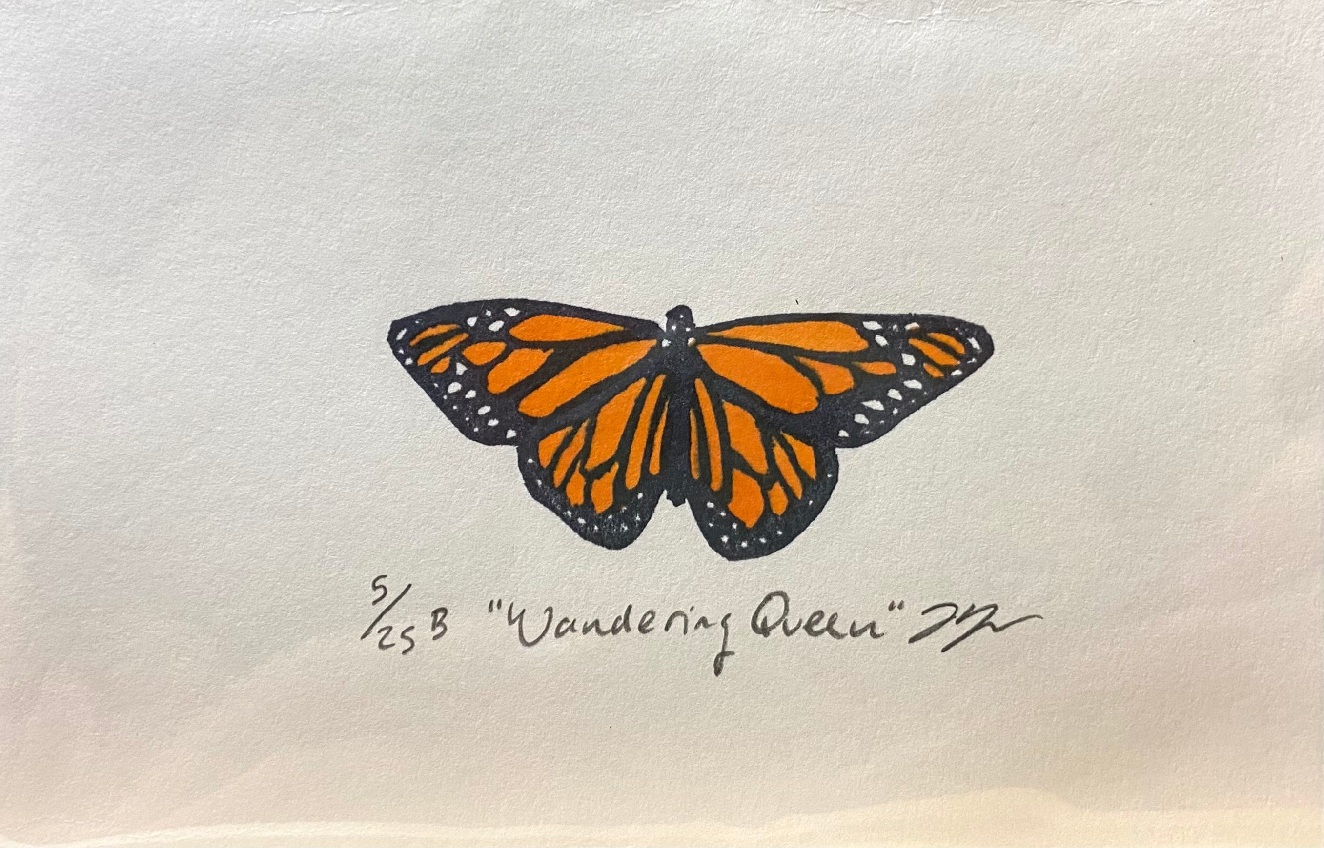 A relief print of a monarch butterfly, made by hand using a carved eraser. The print is numbered, signed, and titled "Wandering Queen".