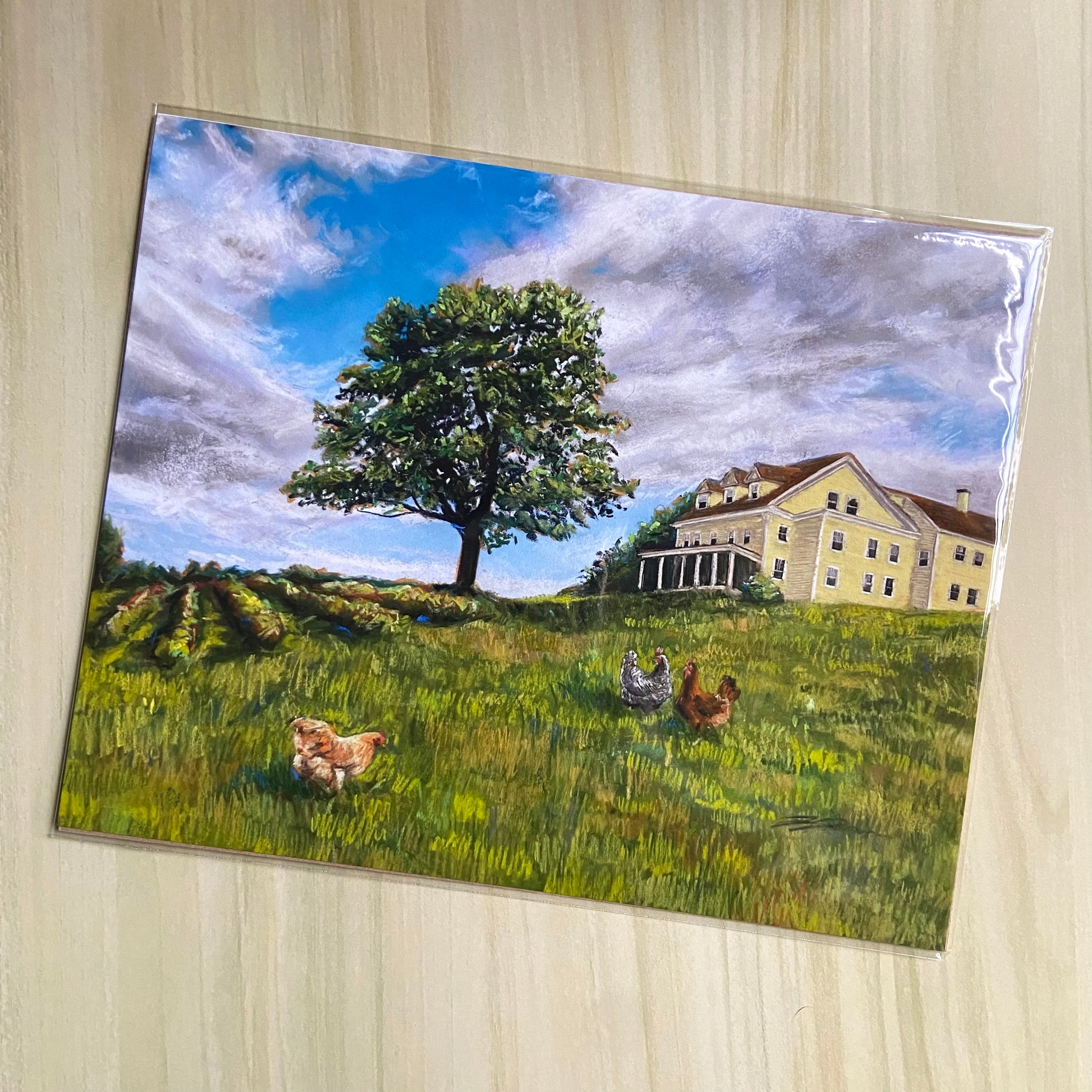 An art print of a soft pastel landscape painting showing a grassy hillside with a yellow farmhouse, chickens, a tree and rows of blueberry bushes. The bright blue sky and textured field grab your eye. This is a nostalgic New England country scene.