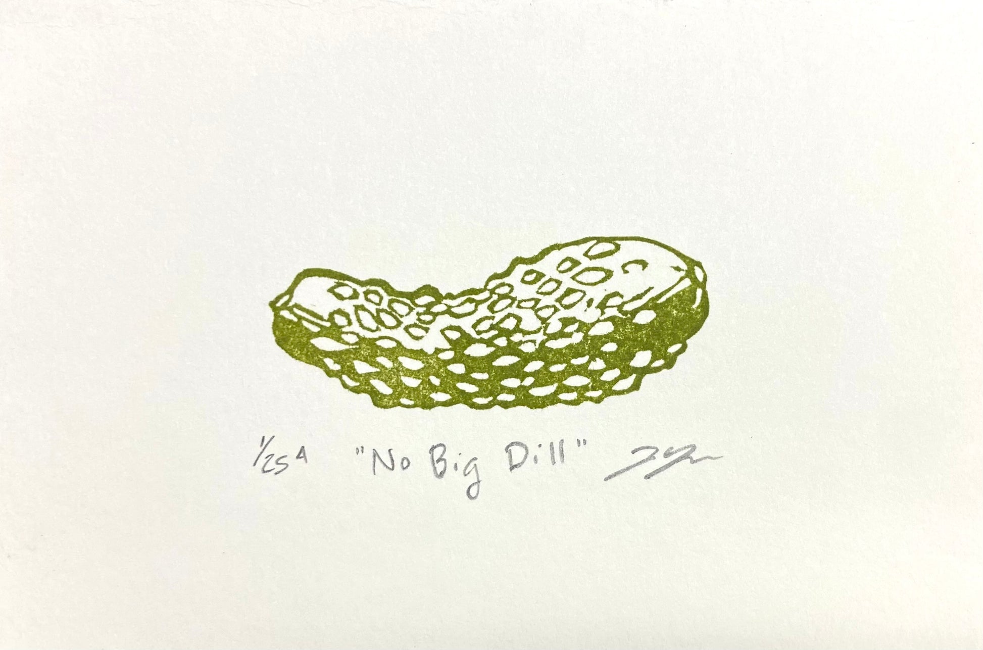 An olive green relief print of a small snacking pickle, titled No Big Dill. The print is handmade with a carved eraser and comes titled, numbered, and signed by hand. 