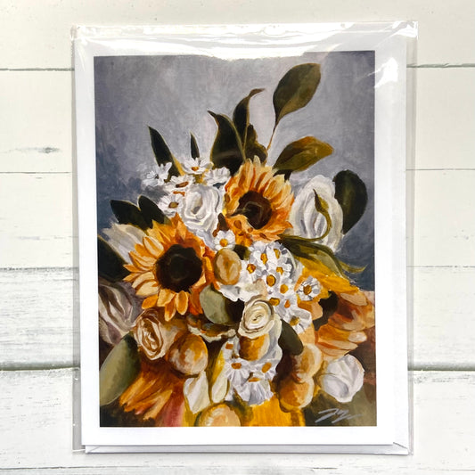 A folded white greeting card of my painting, Green Gold, depicting a bouquet of sunflowers, daisies, and white roses. 