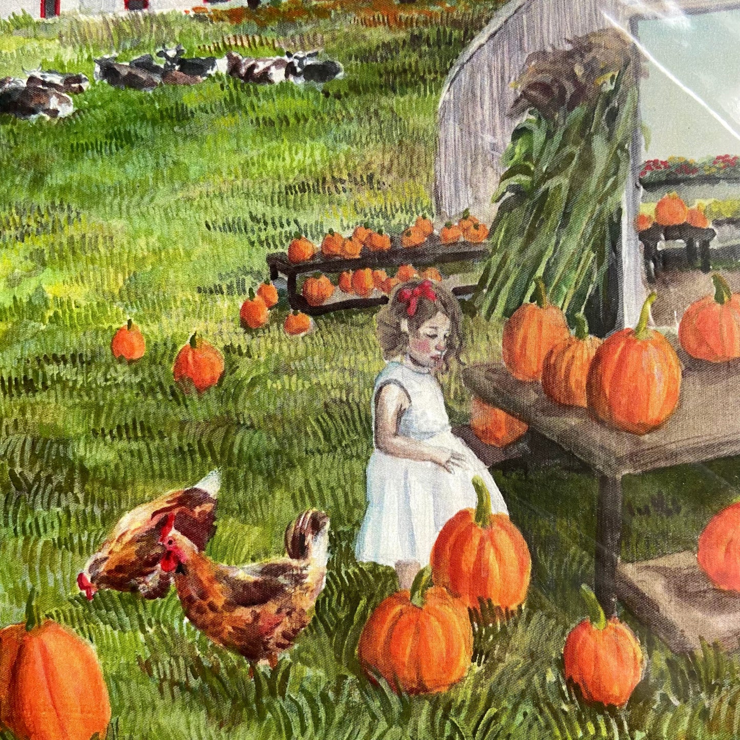 A close-up detail of the art print. In frame are the child, a couple of hens and cows, lots of pumpkins and textured green grass. The illustration uses bright orange and green colors for a joyful and distinctly autumnal vibe.