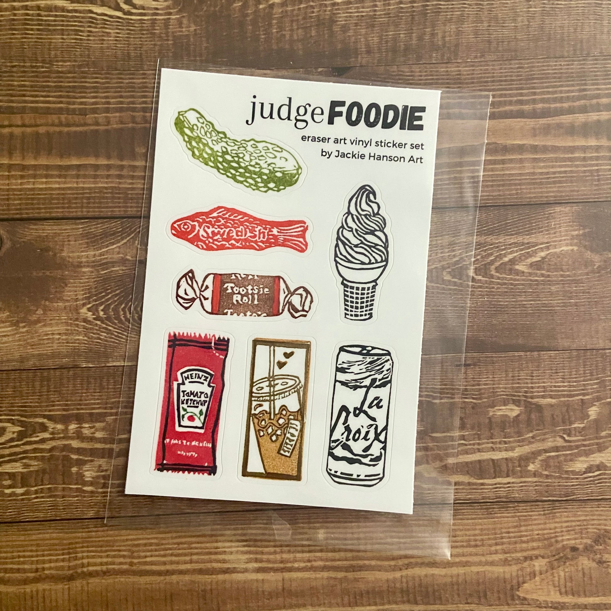 A 4x6 inch sticker sheet titled "judge FOODIE". This set contains seven vinyl stickers of food-related eraser (relief) print designs I created. The pack is wrapped in a protective plastic sleeve. Each sticker is ~1x2 inches and food themed.