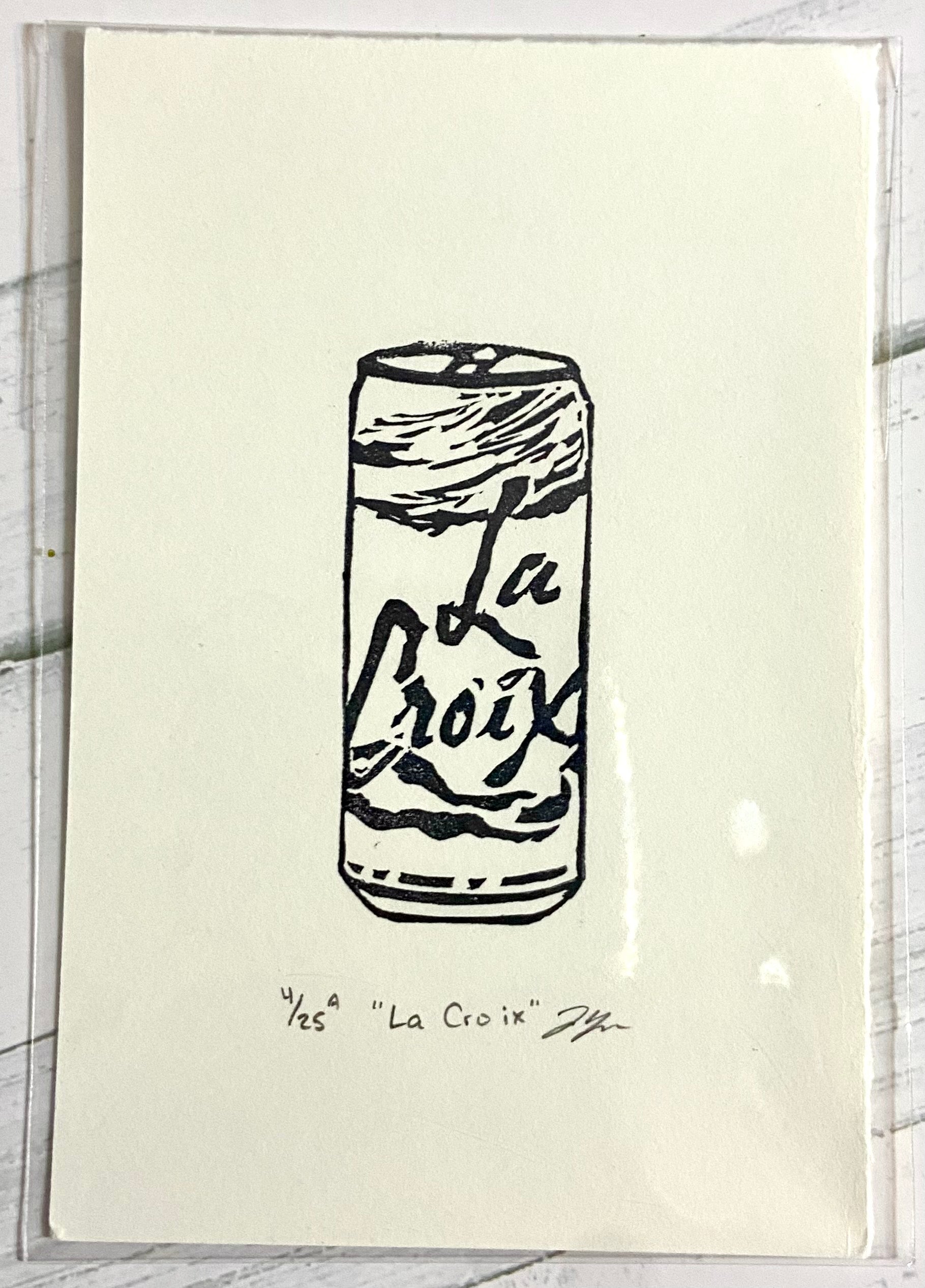 A black and white relief print of a can of La Croix seltzer. The prints are made by hand from a carved eraser and are numbered, titled and signed. 