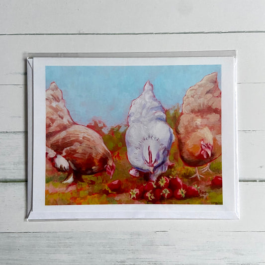 A white greeting card printed with an image of my painting, Strawberry Hens. One white hen flanked by two buff hens peck at a pile of ripe strawberries in this warm-toned acrylic painting. 