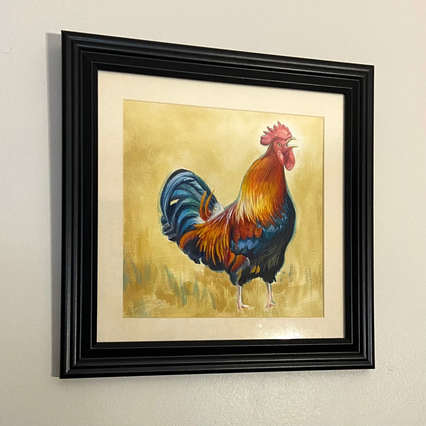 A colorful painting of a rooster cawing in front of an abstract beige background. The painting is in a black frame with a white mat.