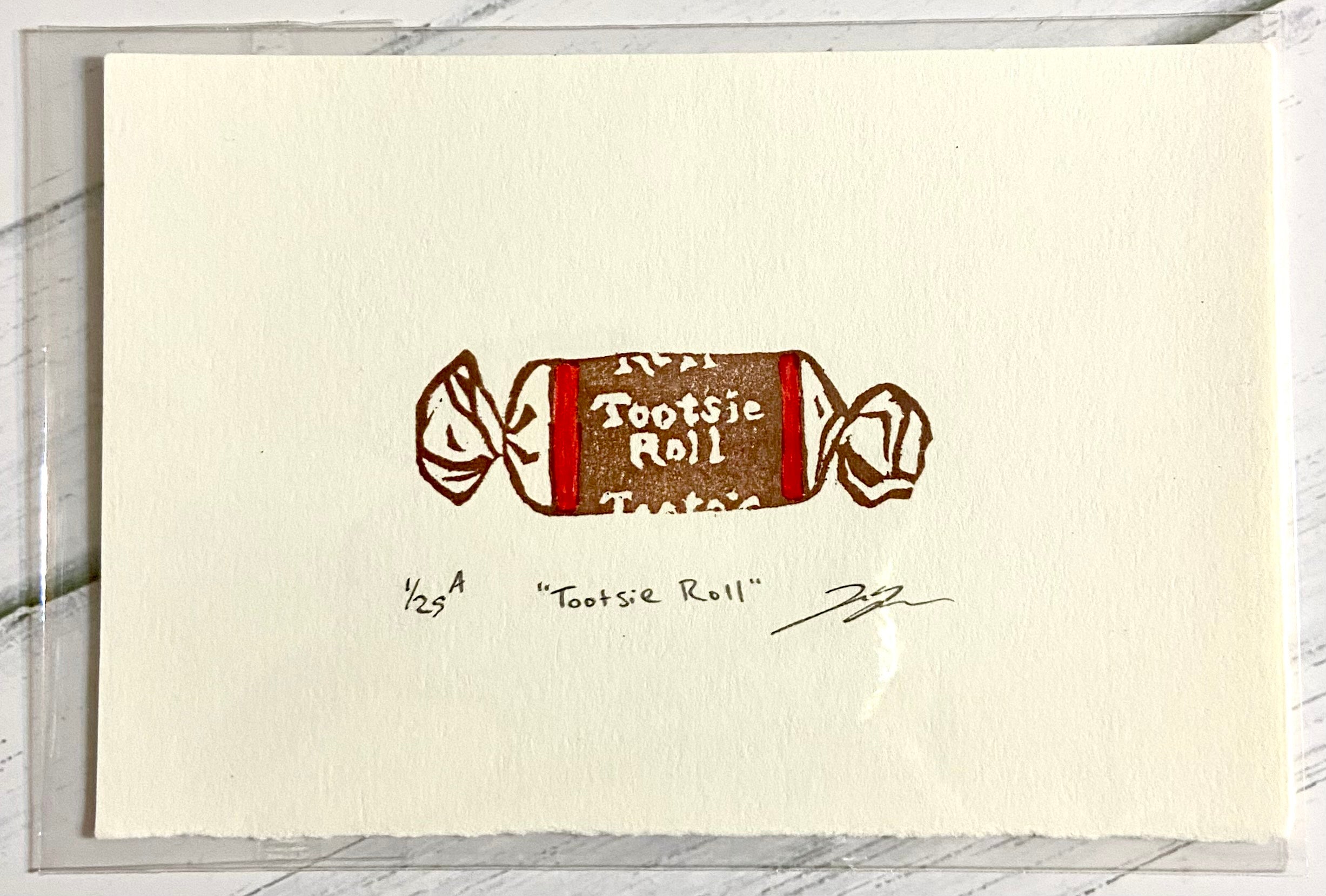 A two-color relief print of a Tootsie Roll candy. The prints are made by hand from a carved eraser and are numbered, titled and signed.