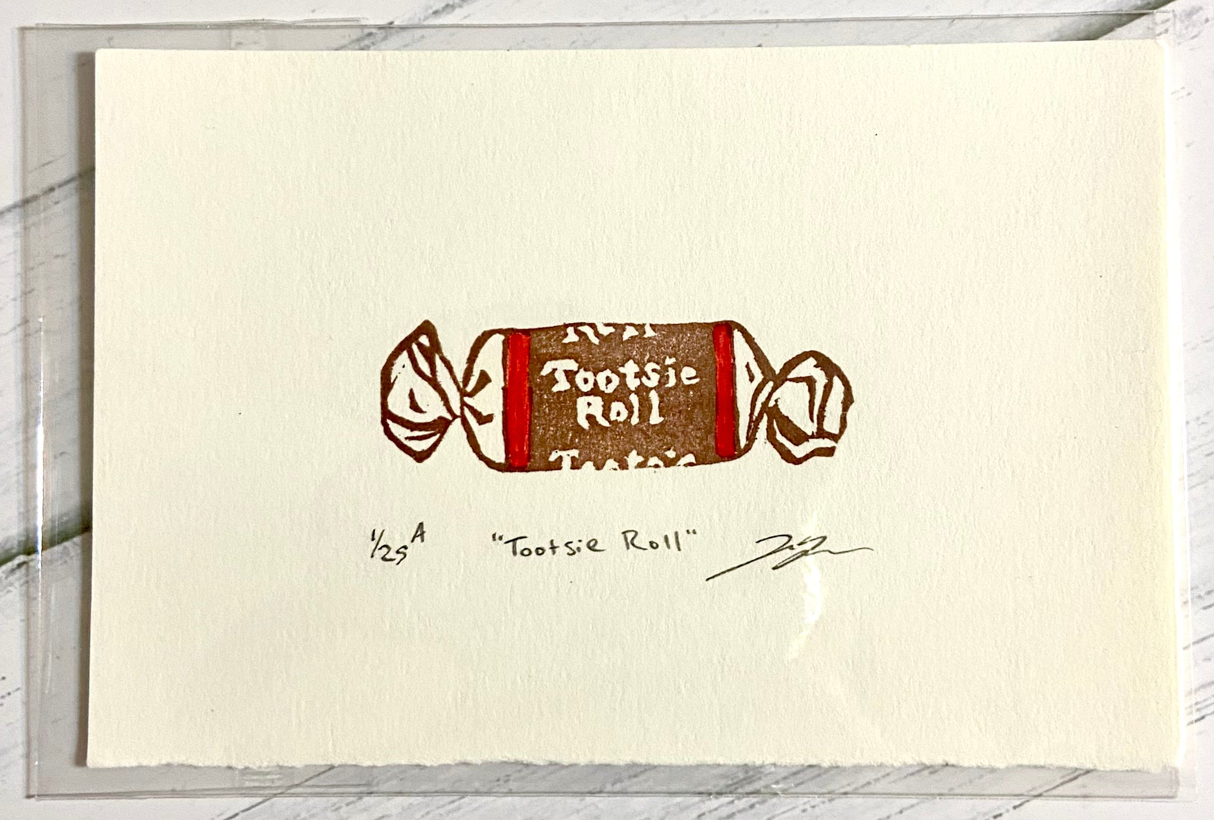 A two-color relief print of a Tootsie Roll candy. The prints are made by hand from a carved eraser and are numbered, titled and signed. 