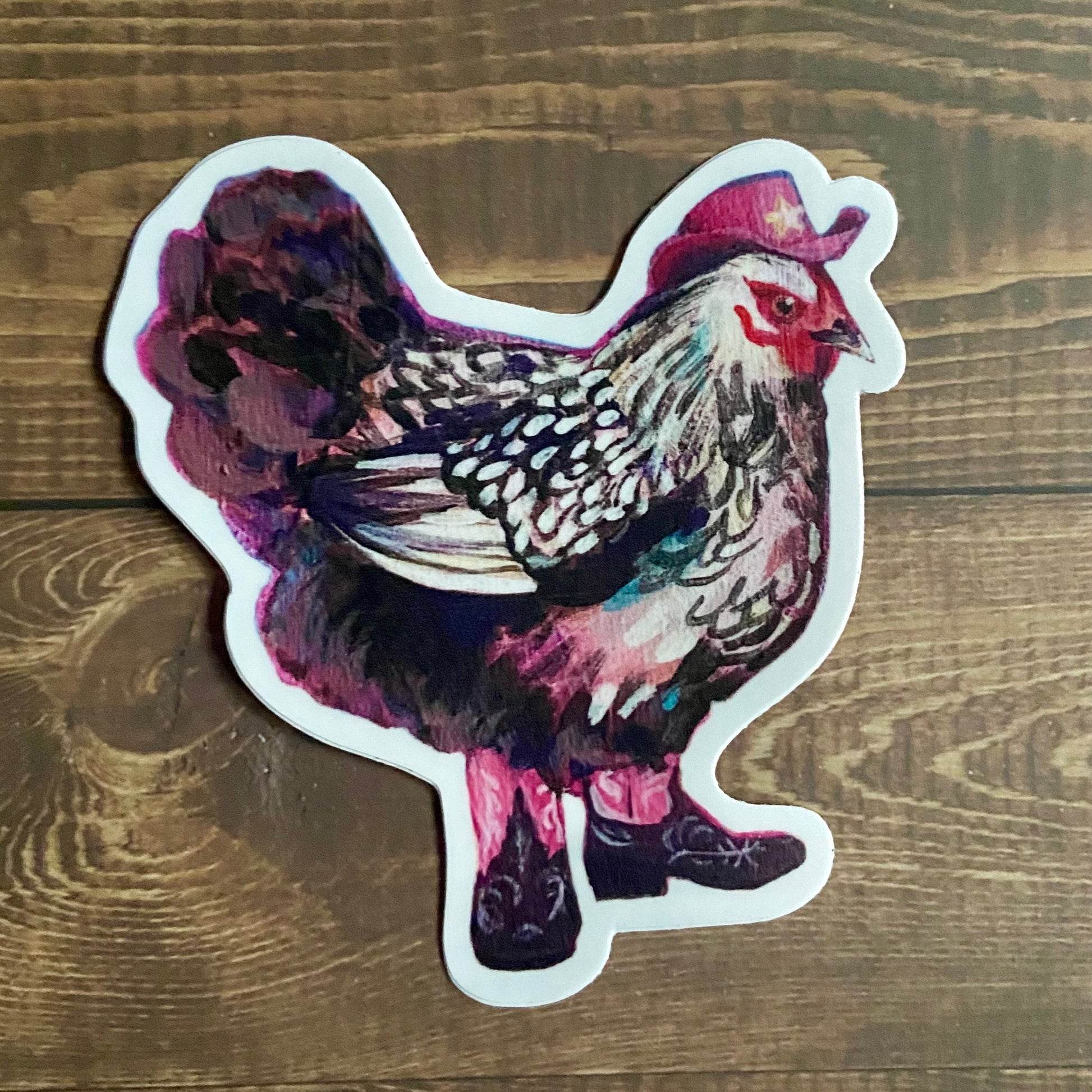 A die-cut vinyl sticker of a painted black-and-white chicken in pink cowgirl boots and hat.